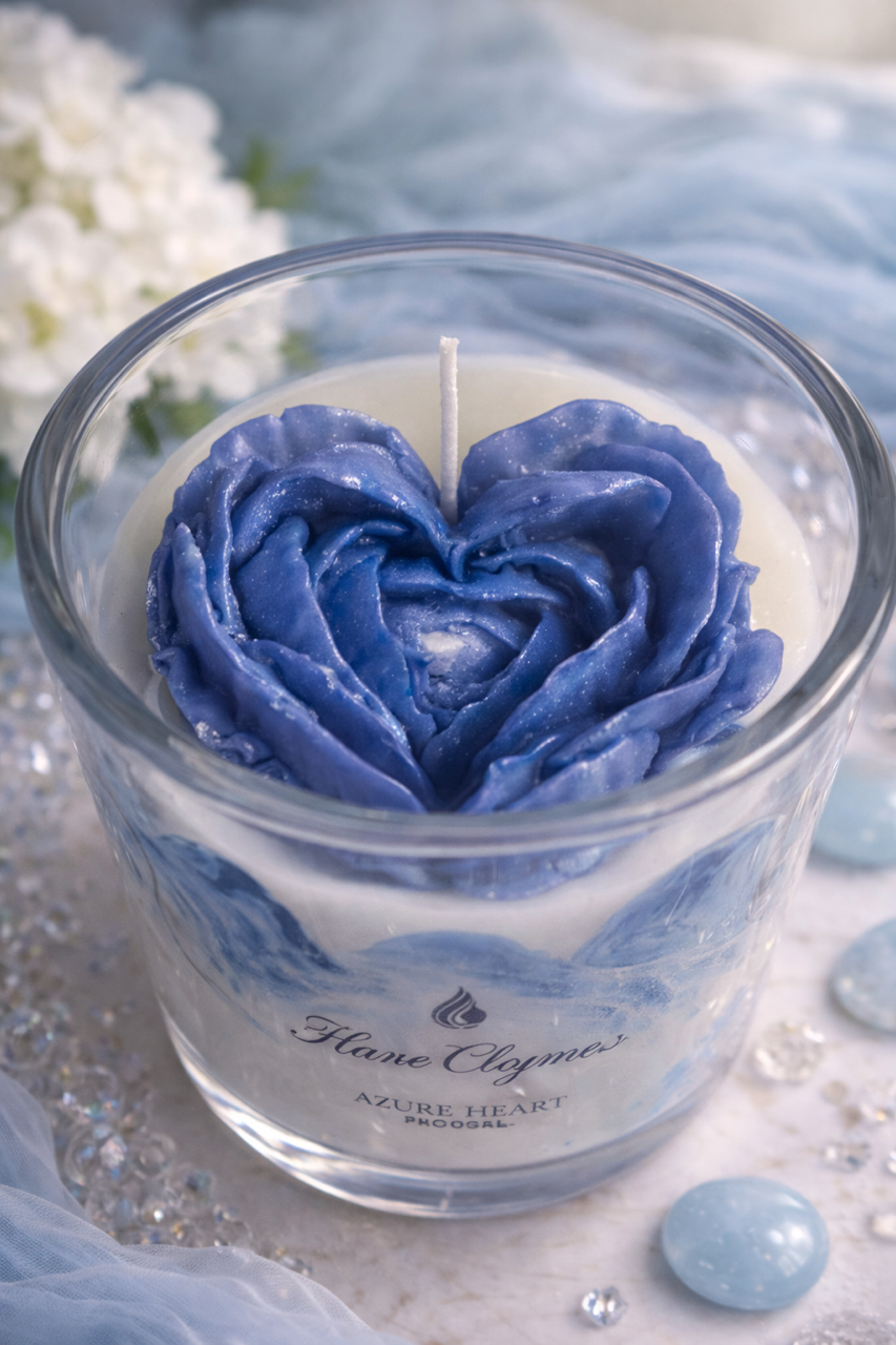 Blue rose-shaped candle in a glass container with 'Hane Cluny' branding on a light background.