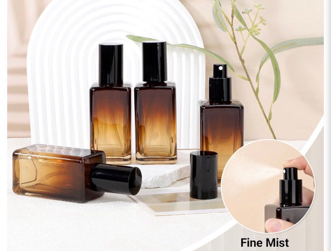 Four Amber Noir glass bottles with a small circle image in right corner showing the perfume spray and below it says fine mist by Flame Elegance. 