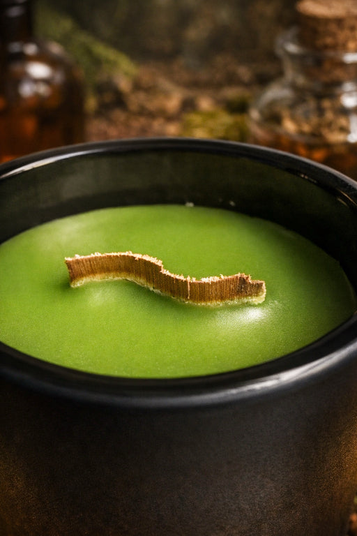 close up of luxurious apothecary aromatherapy curved wood wick in black ceramic vessel.  Hand poured and forest green color soy wax 