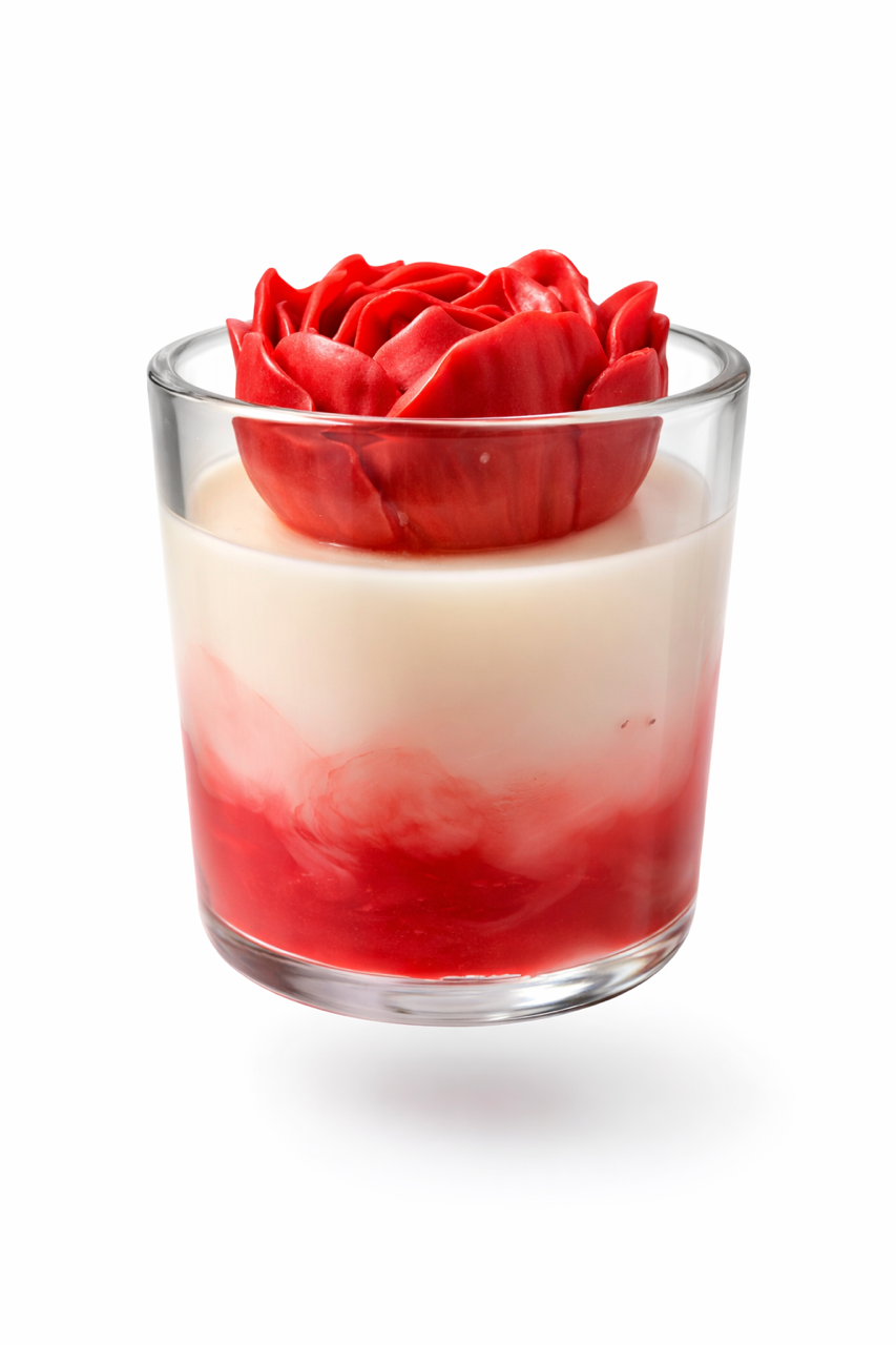 Red and white soy wax marbled base filled with ivory soy wax and topped with red soy wax heart rose candle. In a clear glass vessel. White background. 