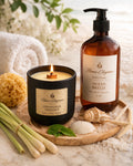 lemongrass candle  and ocean breeze body wash on wood table with seashells and sand in background