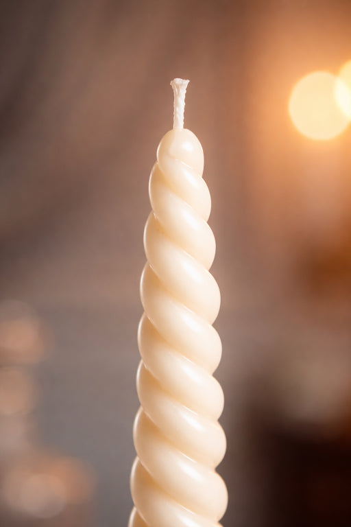 Hand poured soy wax and beeswax close up spiral taper candle unscented ivory 11.4 inch close up with blurred background
