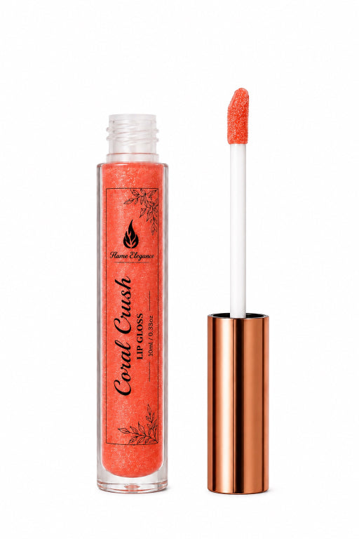 A coral tube of coral lip gloss with a metallic rose gold cap, shown next to its applicator wand on a white background. The label reads 'Coral Crush Lip Gloss' by 'Flame Elegance