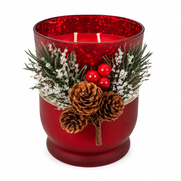 Decorative red candle holder with pine cones and berries on a white background with two wicks and soy wax candle scented with sugar plum by Flame Elegance. 