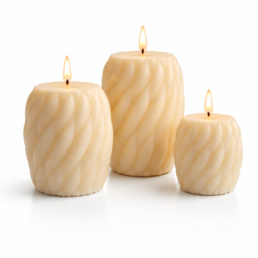 Large, medium, and small ivory spiral pillar candles glowing with warm candlelight with white background