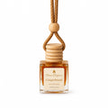 A Flame Elegance Gingerbread car diffuser featuring a clear glass bottle filled with amber liquid, a light wood beaded cap, and a braided tan cord, shown on a white background.