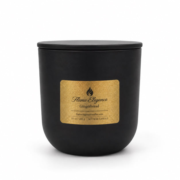 A matte black jar candle with a matching lid and a textured gold label reading 'Flame Elegance Gingerbread' on a clean white background.