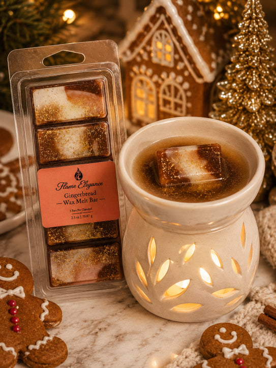 Flavors of Flame Elegance  Gingerbread Wax Melt Bar in a clear plastic clamshell package, displayed next to a lit white ceramic wax warmer filled with melted wax, with gingerbread cookies and a holiday house decoration in the background.