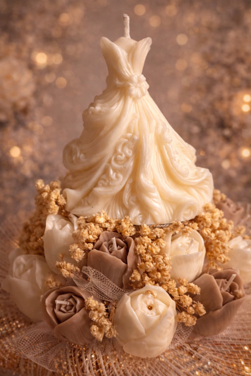 up close photo of elegant sculpted wedding gown and floral tulip candle bouquet adorned with baby's breath scented with love spell fragrance by Flame Elegance. 