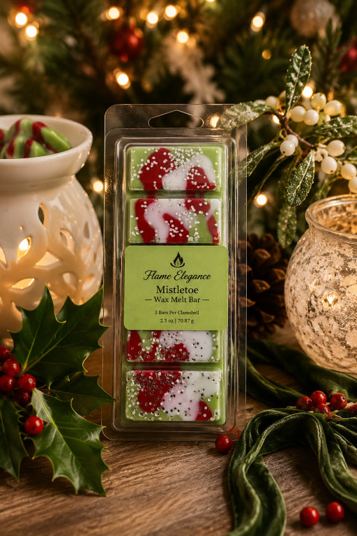 A 5-piece Christmas Mistletoe wax melt bar set in a clear plastic clamshell package with a green label, styled on a wooden table with holiday decorations including a white ceramic wax warmer, a lit candle, holly, and pine branches by Flame Elegance