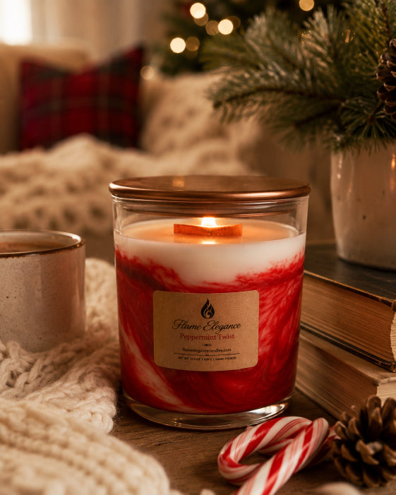 Peppermint twist scented candle wood wick by Flame Elegance with two candy canes. Candle sitting on table with bronze lid and blurred background with tree and couch. 