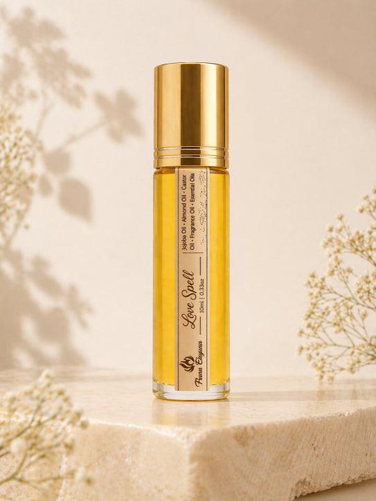 Gold bottle of 'Love Spell' natural luxury perfume oil on a beige background with floral elements