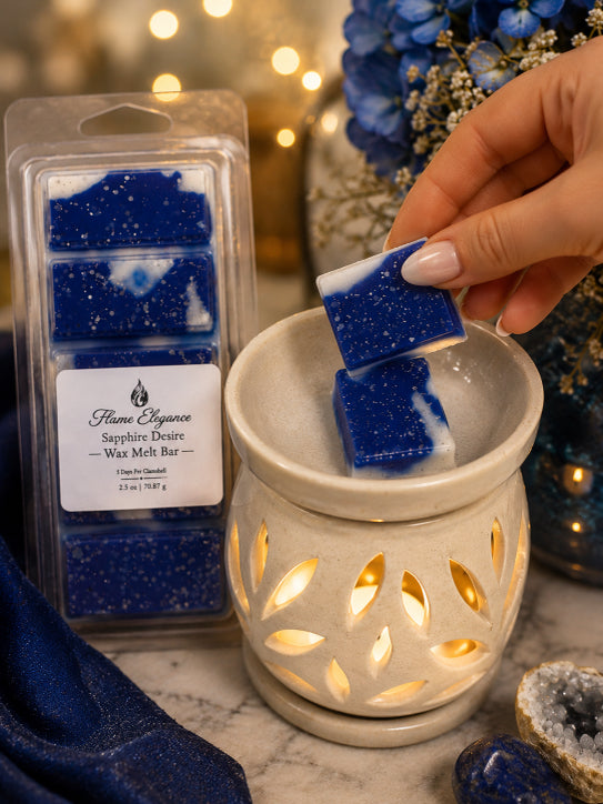 A hand holds two blue and white wax melts above a lit cream-colored ceramic scented candle holder, with a packaged wax melt bar set standing nearby on a marble surface.