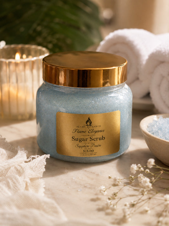 Jar of sugar scrub with gold lid and label on a surface with candles and towels in the background by flame elegance