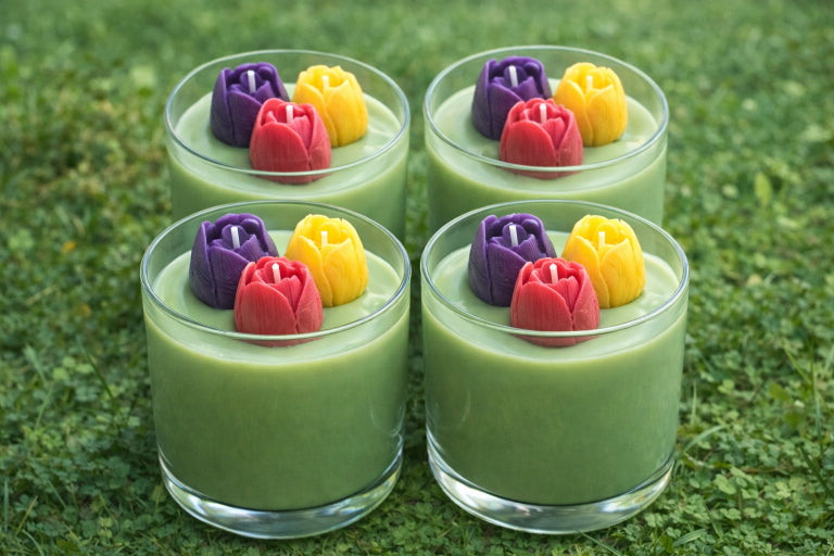 four tulip garden candles by flame elegance inspired by spring flowers and floral fragrance with three colored tulip sculpted candles on top. 